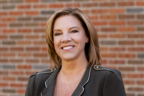Outdoor business headshot of Debbie with a brick background