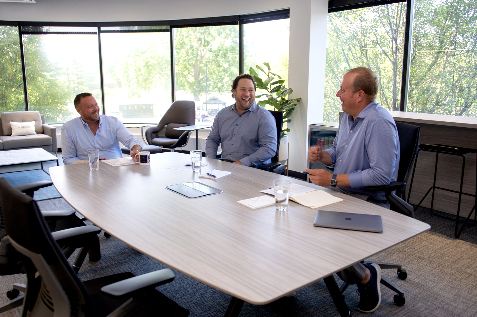three business leaders talking around conference table