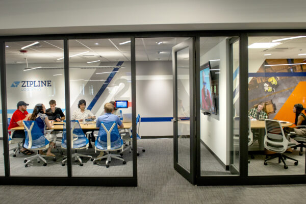 coworkers in a meeting inside a glass walled office space