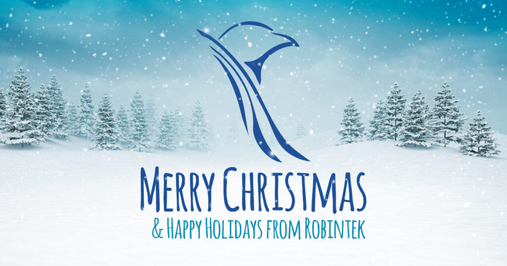 snowy scene with snow covered pines and flurries in a blue sky with the text overlay "Merry Christmas and Happy Holidays from Robintek"